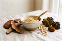 Bol de poudre d'extrait de champignons riche en bêta-glucanes entouré de reishi, de chaga et d'un épi d'avoine