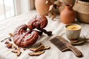 Champignons reishi rouge brillant avec peigne en bois et boisson adaptogène dorée